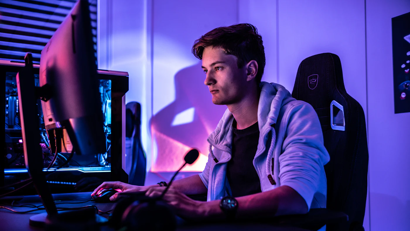 Un streamer en live devant son setup, micro et écran allumés